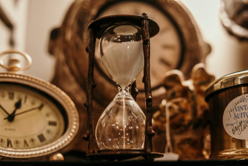Vintage gold room with hourglass in the center and a clock in the background
